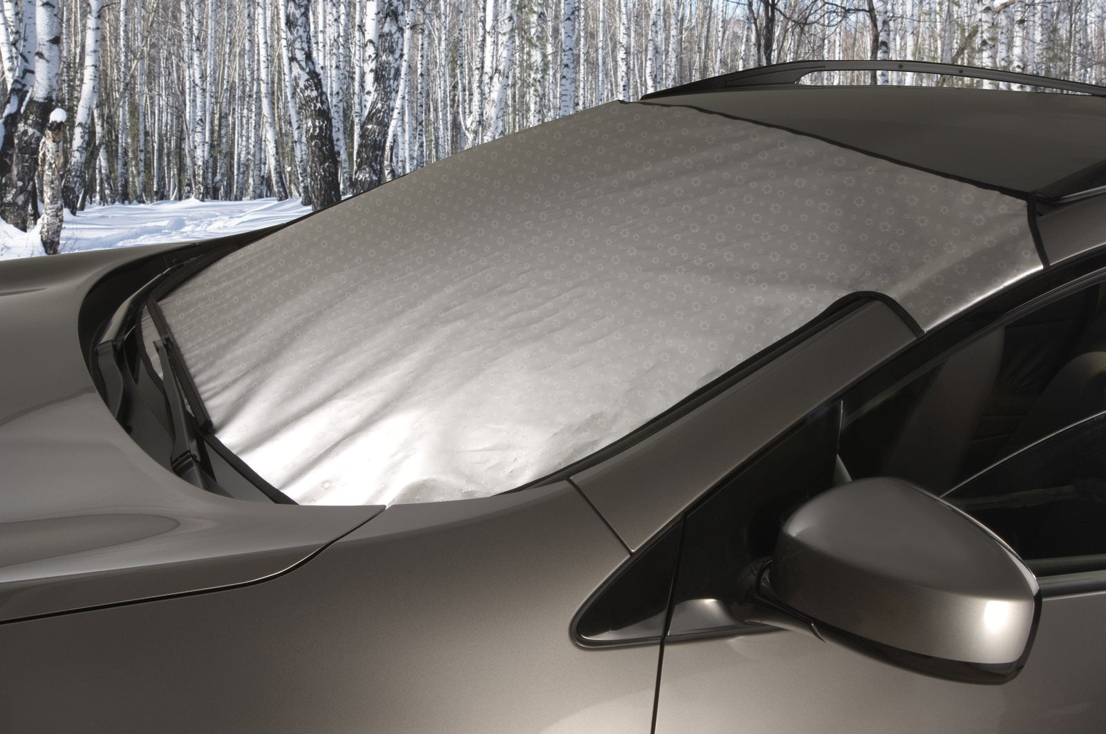 Custom SnowShade covering a car windshield in a winter setting